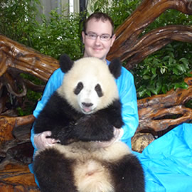 Photo of Neil with a Panda at the Chengdu Panda Sanctuary when in Chengdu, China